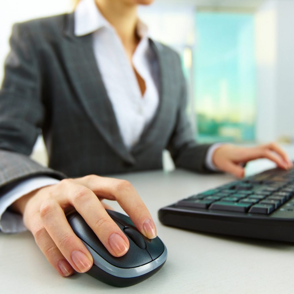 image of female hands pushing keys of a computer mouse and keyboard