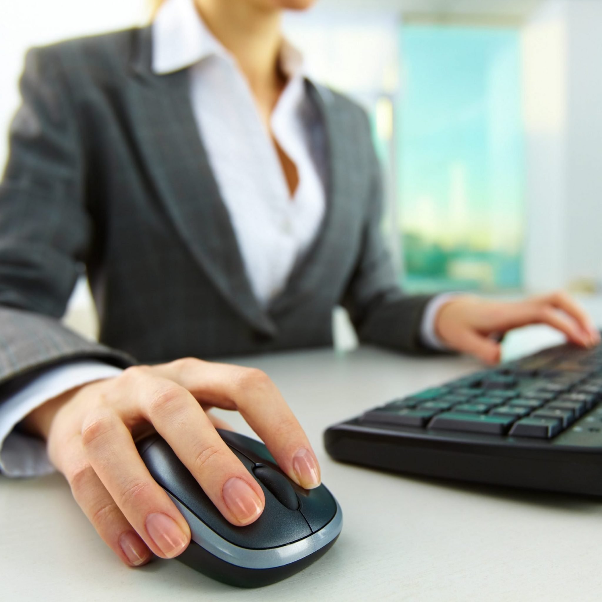 image of female hands pushing keys of a computer mouse and keyboard